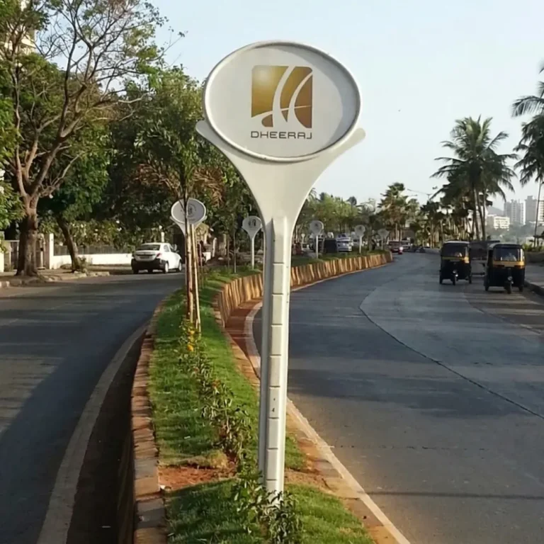 Row of FRP lollipop signage boards with Dheeraj branding along a road divider