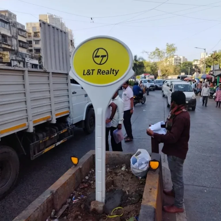 Branded FRP lollipop signage board for L&T Realty installed on a busy market road