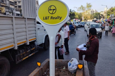 frp lollipop signage board lt realty installed site Branded FRP lollipop signage board for L&T Realty installed on a busy market road